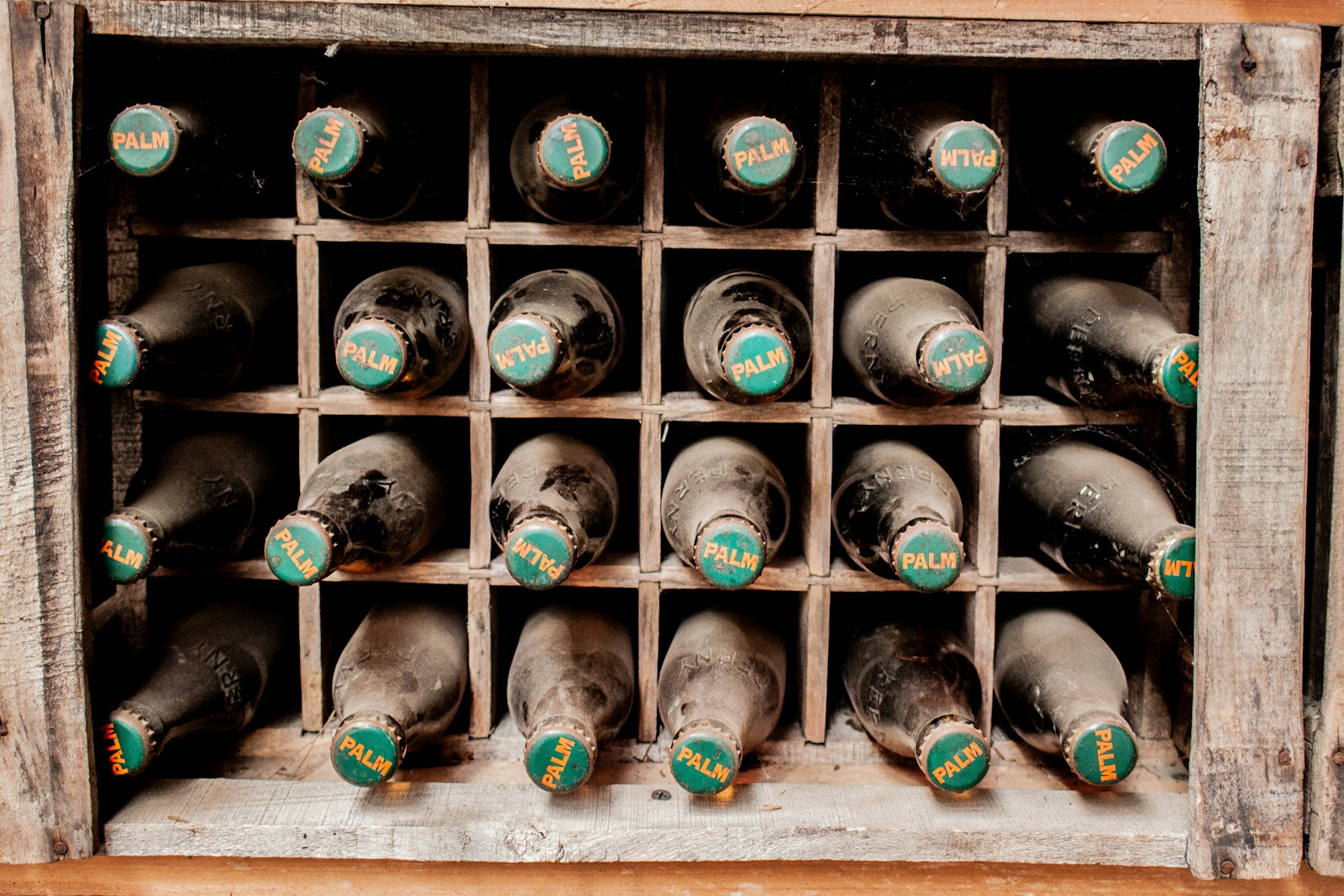 A wooden wine rack filled with lots of bottles